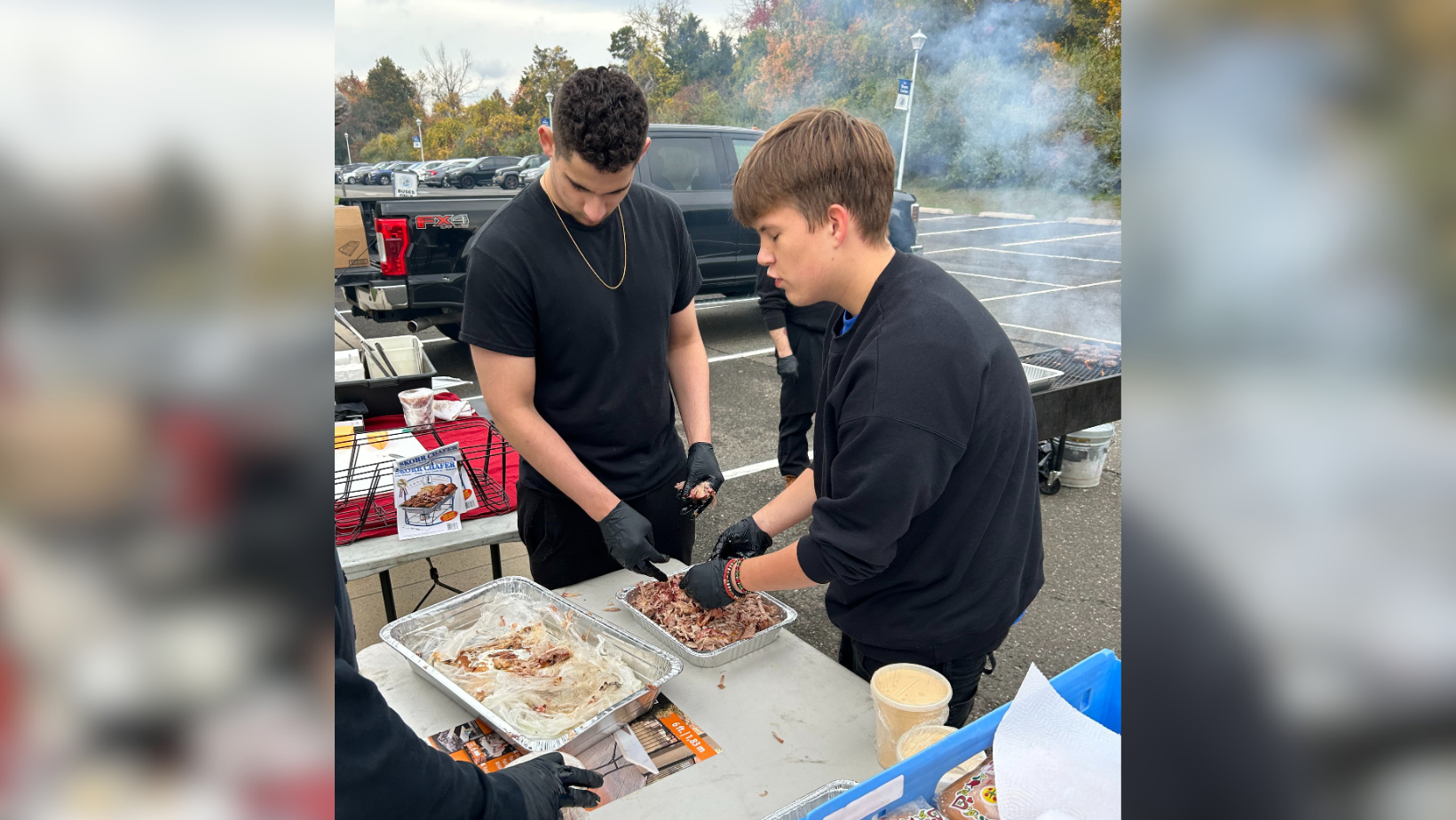 Students cooking in a barbeque outdoors