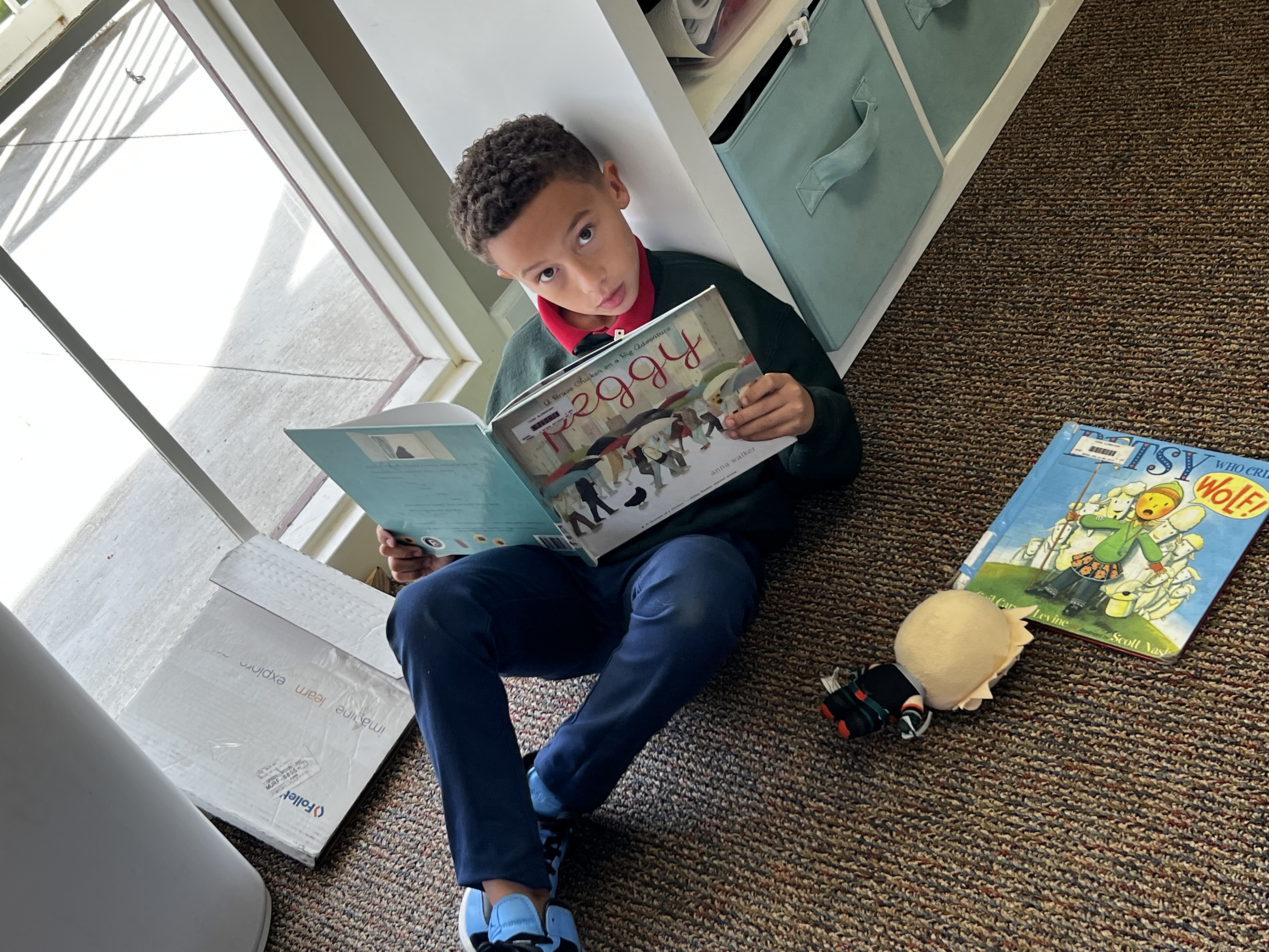 Male student reading a book in the library. 