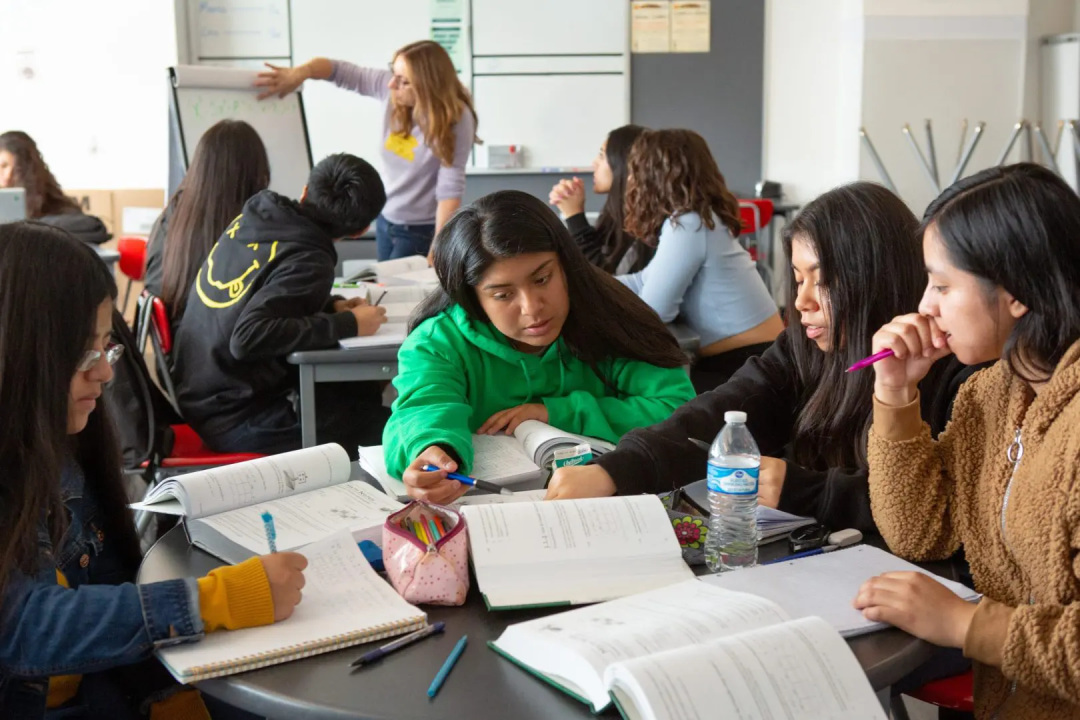 students sitting together at a table with books