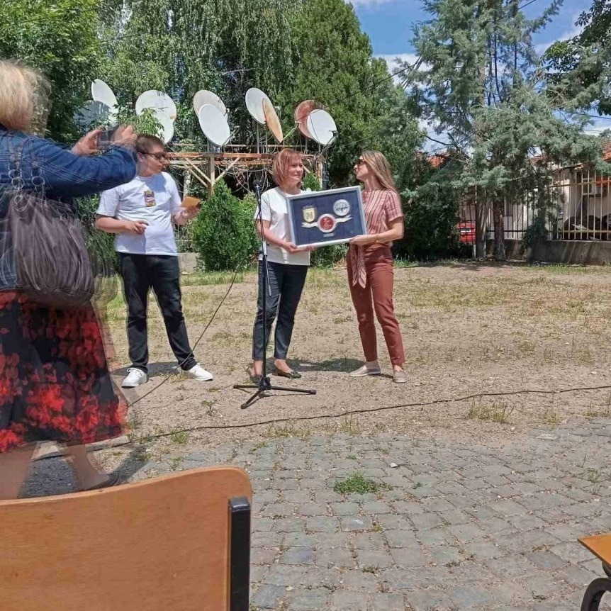 NOVA representatives presenting a donation plaque outdoors