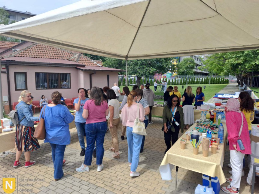 Staff gathering at the PTA appreciation buffet under a canopy