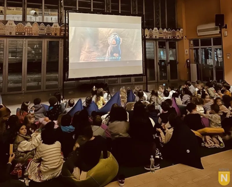 Students watching a film on a large screen at movie night