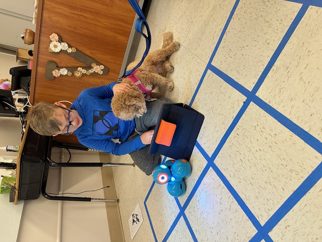 Phoebe the therapy dog with student at AWR