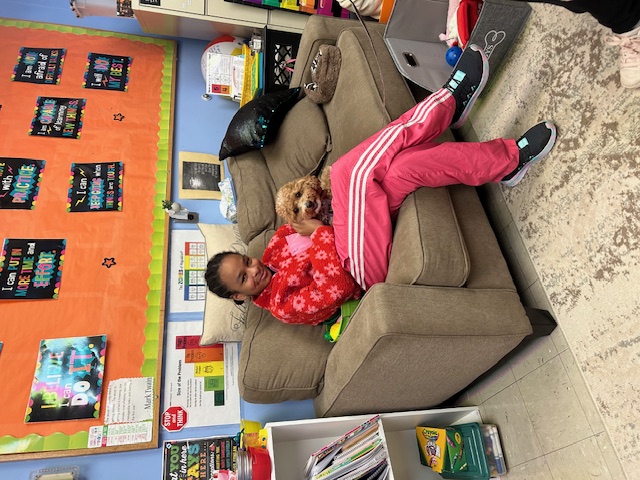 Phoebe the therapy dog with student at AWR