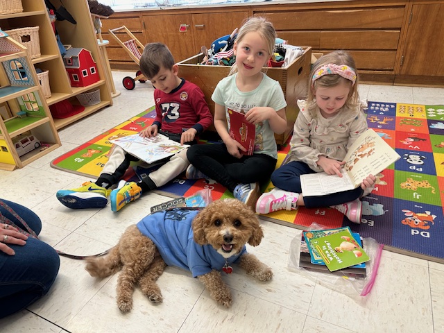 Phoebe the therapy dog with students at AWR