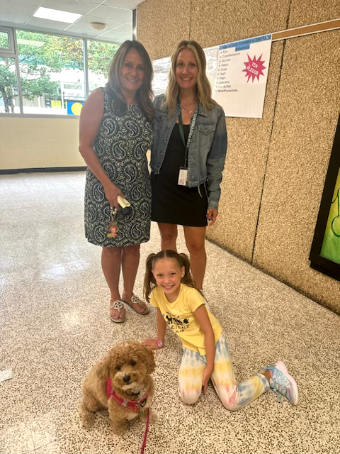 phoebe the therapy dog with two teachers and student