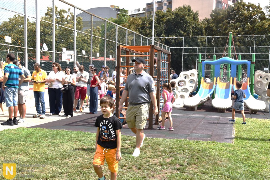 Families gathered by the playground during the BBQ social