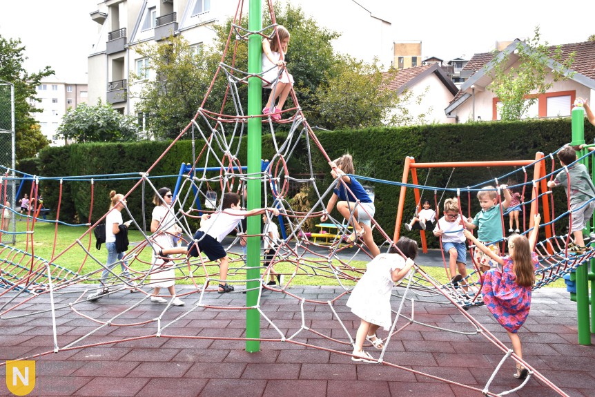 Children climbing the rope playground frame at the BBQ social