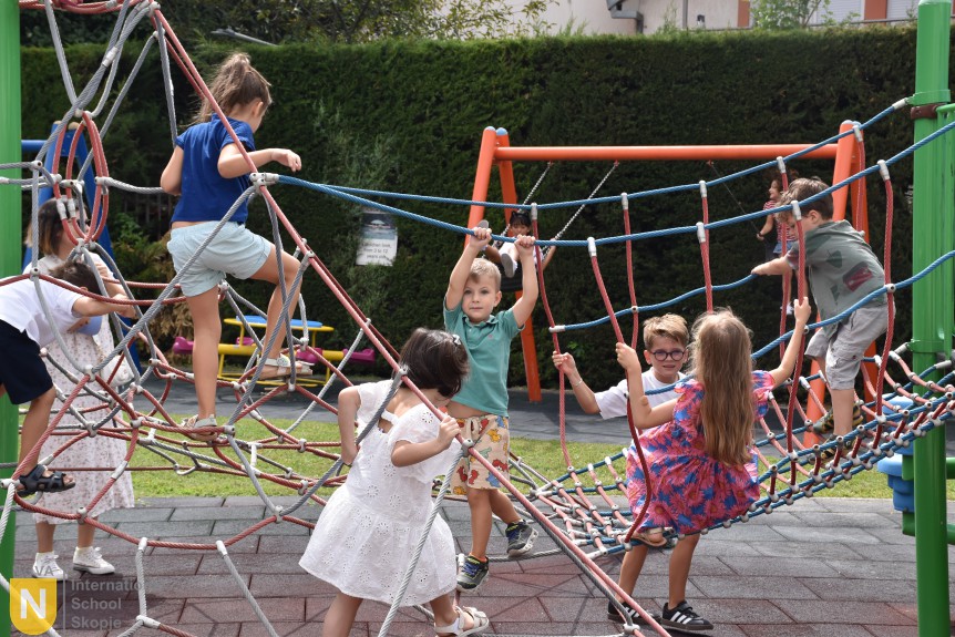 Children climbing on the playground rope structure at the BBQ social