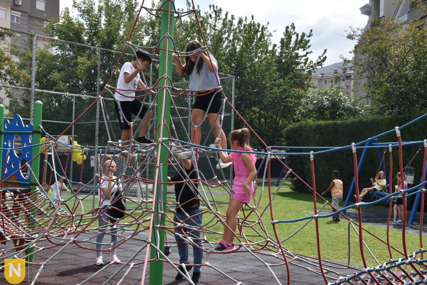 Children playing on the playground climbing net during the BBQ social