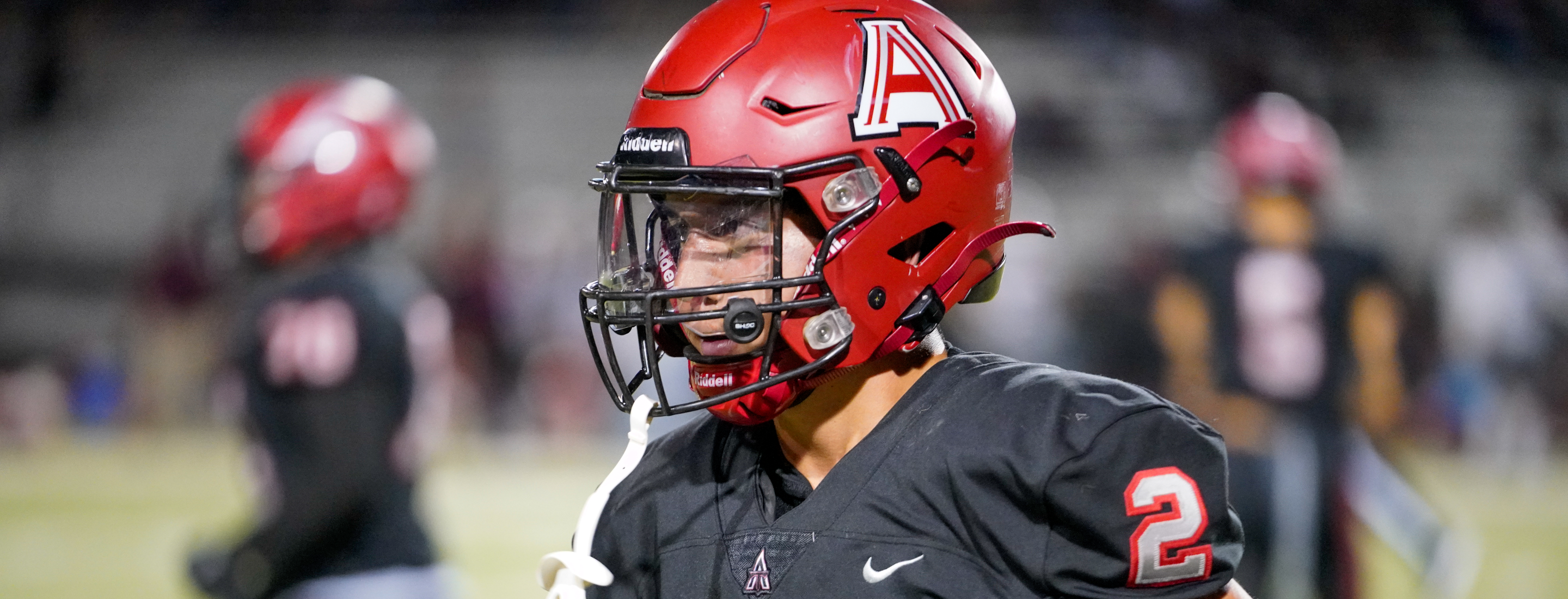 Student in football uniform and helmet.