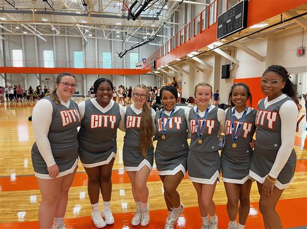 cheerleaders in gray uniforms in gym