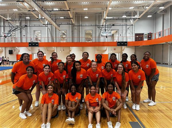 cheerleaders in gray uniforms holding awards