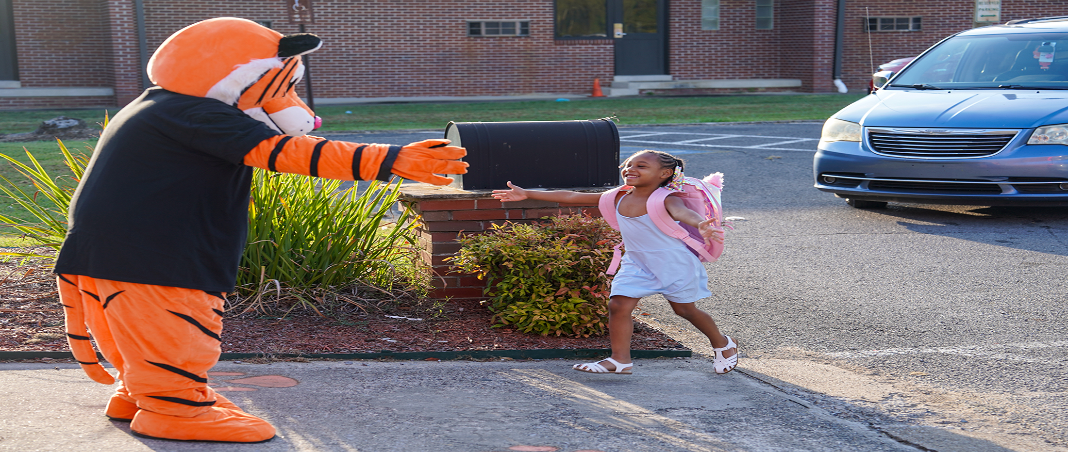 small child runs toward Tiger mascot