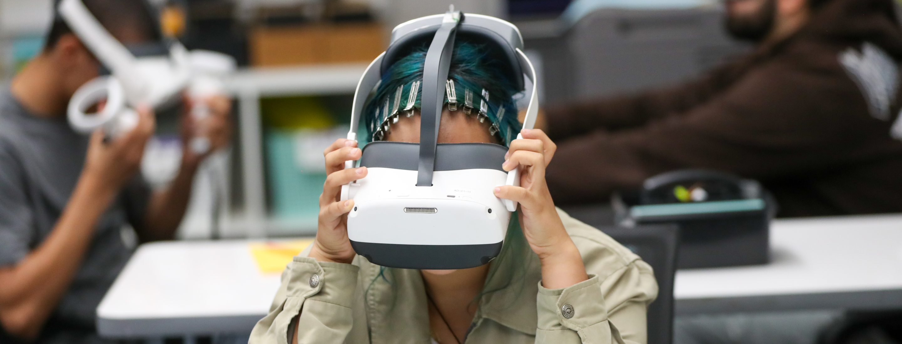 A person wearing a virtual reality headset, with a blurred background of what appears to be an indoor setting.