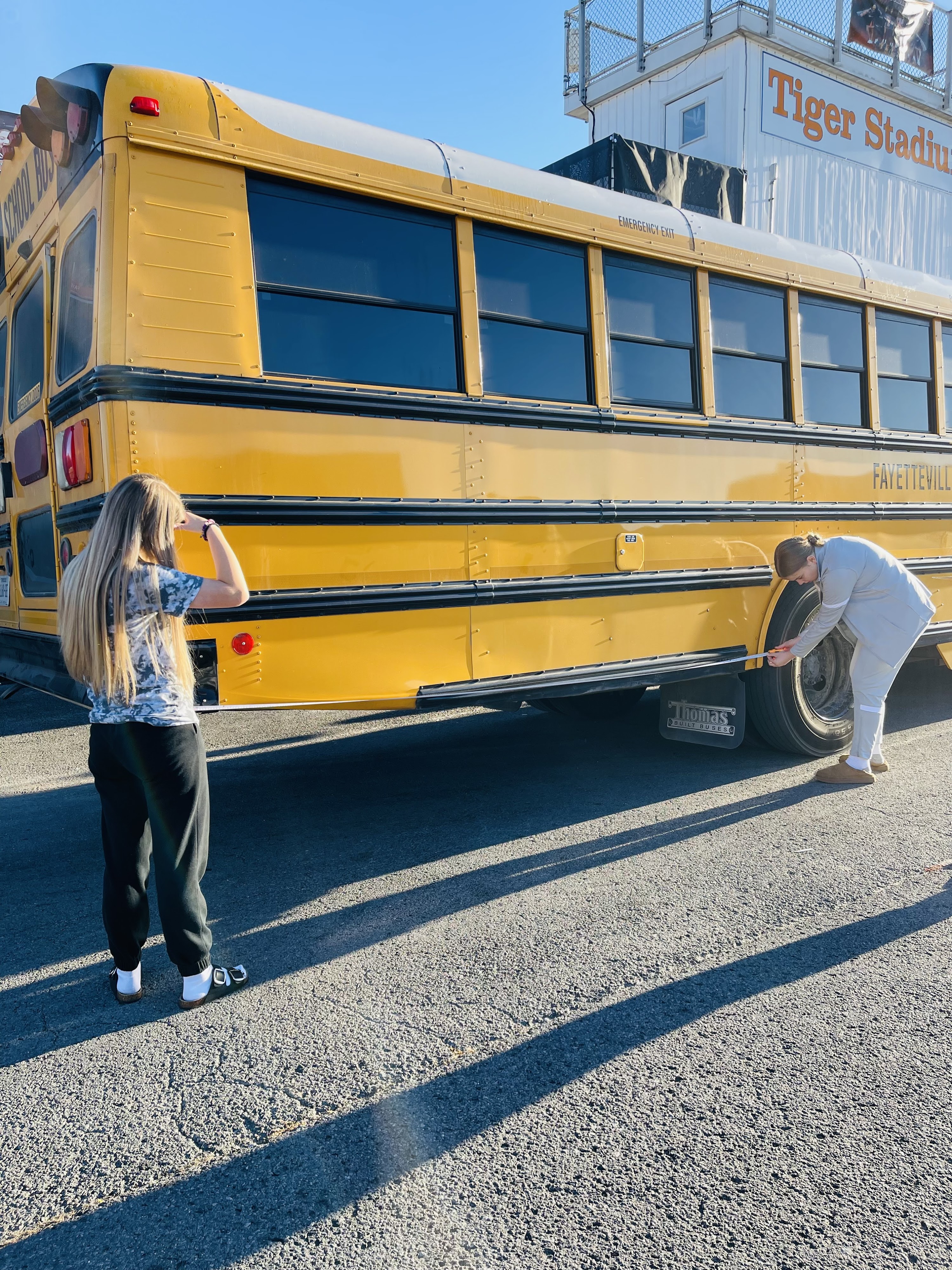 students measuring school bus