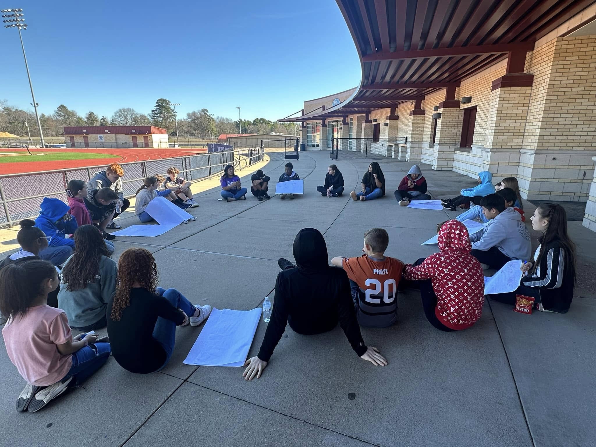 West Rusk Junior High Sources of Strength students sit in a circle outside