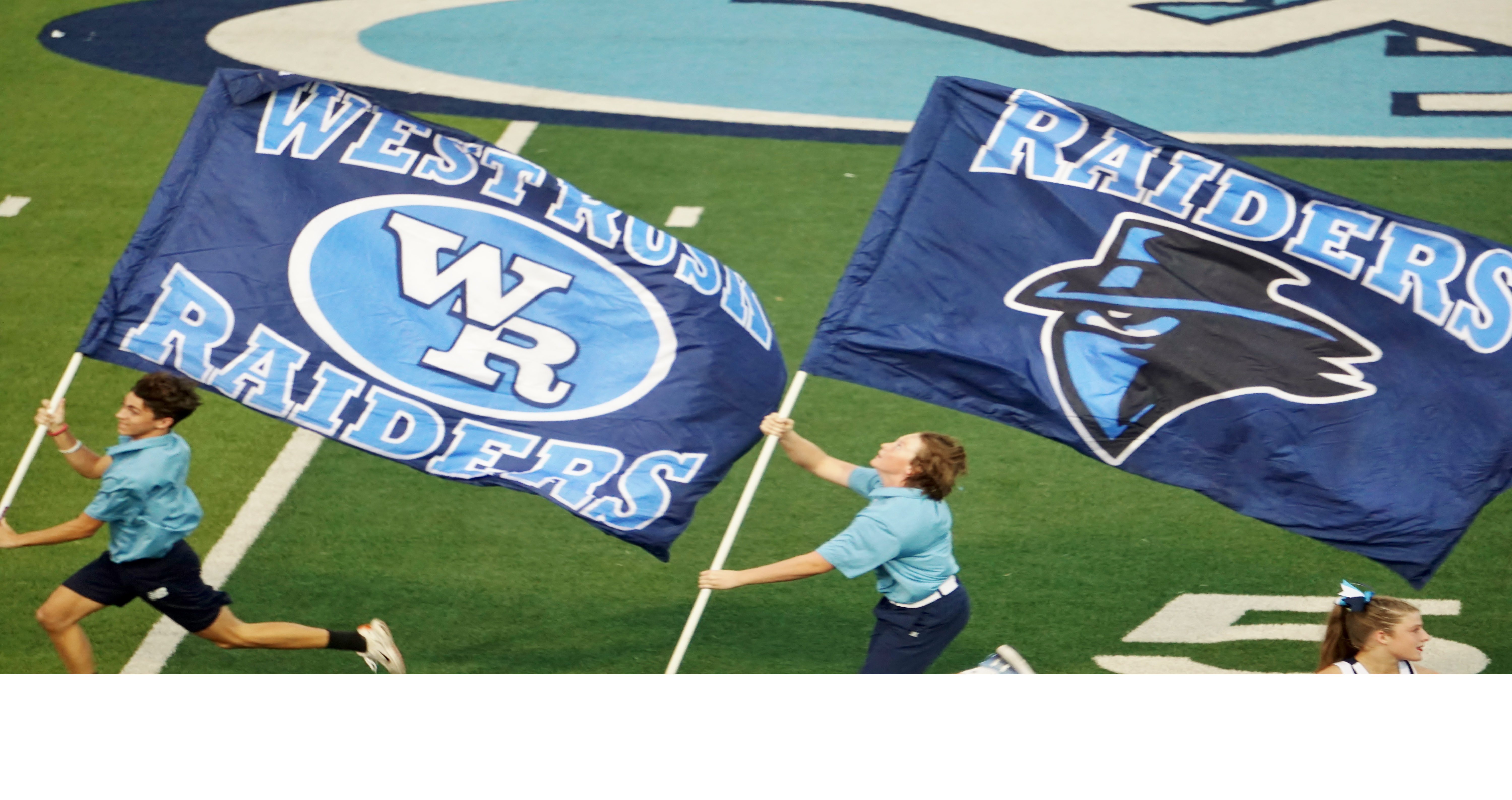 West Rusk CCISD students running with the West Rusk Raider flags on the football field