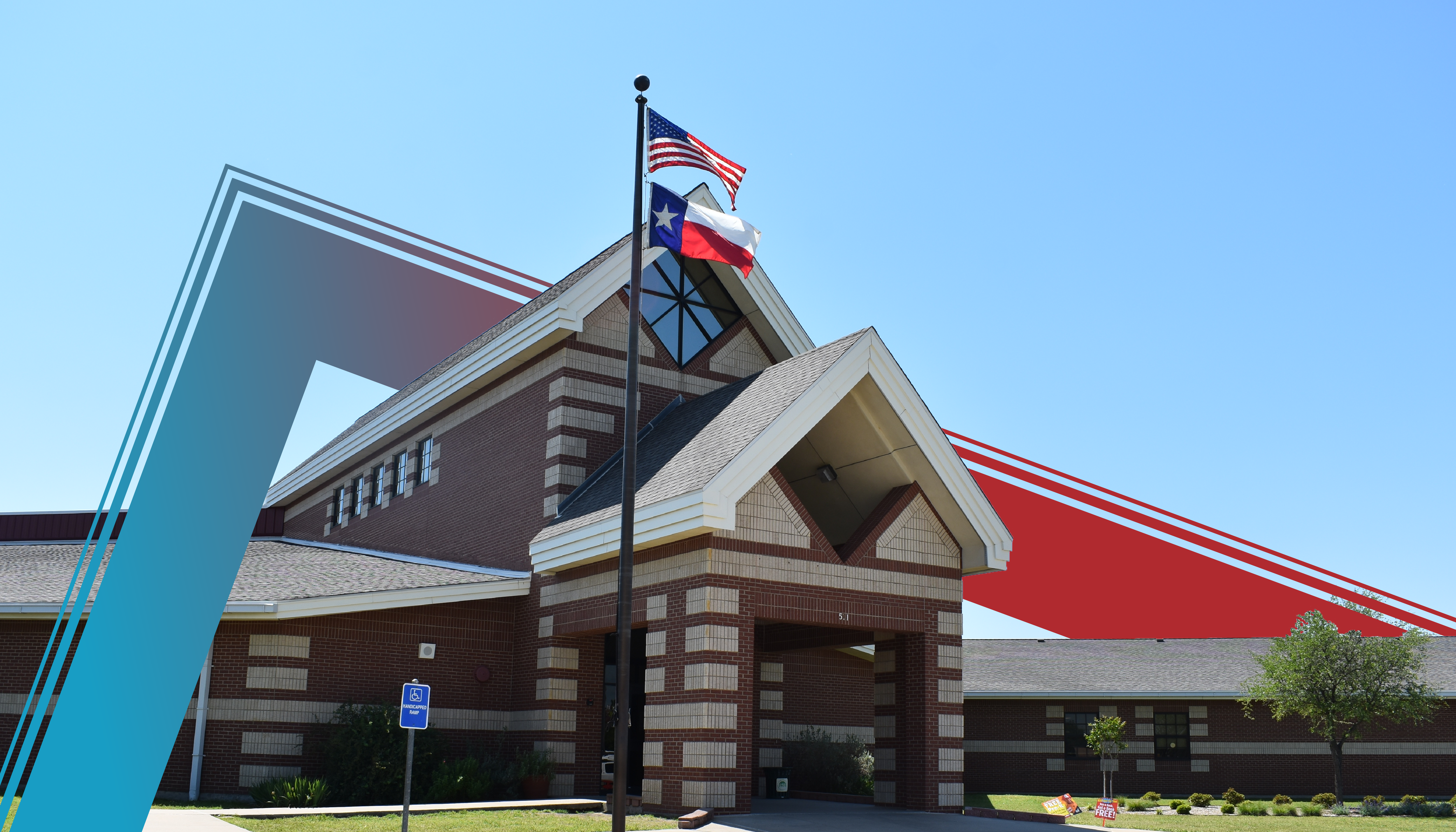 A large, modern building with a prominent American flag flying atop, set against a clear blue sky.
