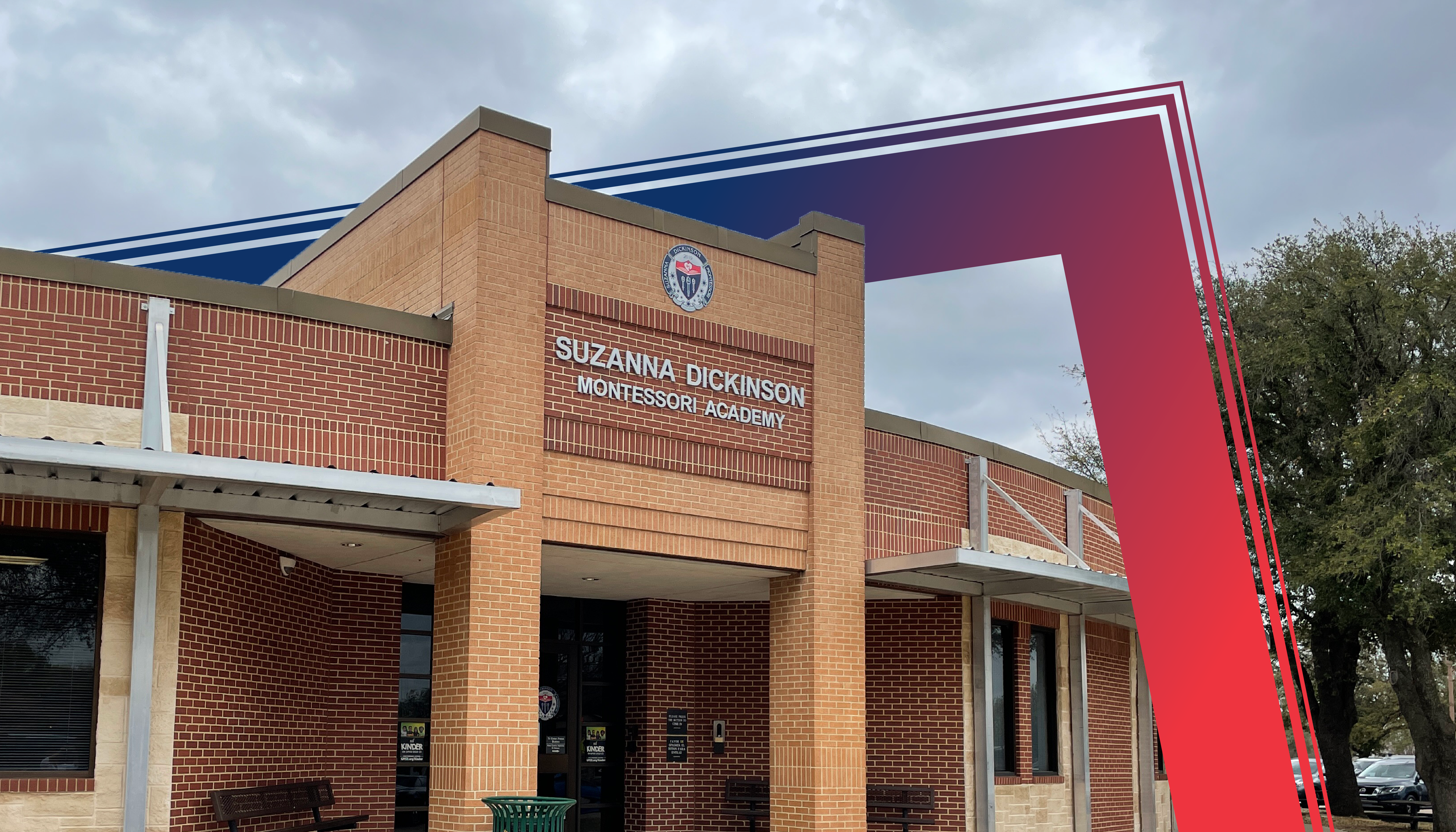 A brick building with a red and blue exterior, featuring an entrance and signage for the Suzanne Dickinson Elementary School.