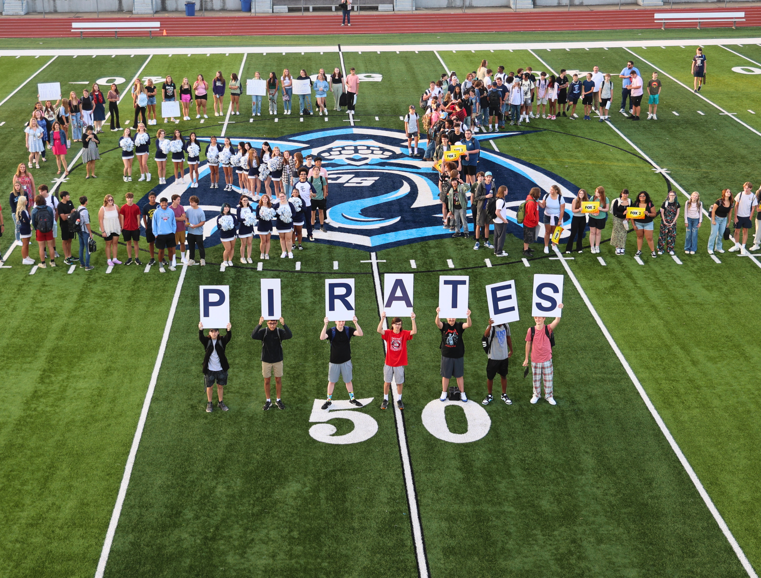 photo of SCHS students forming an S and C and holding "PIRATE" signs