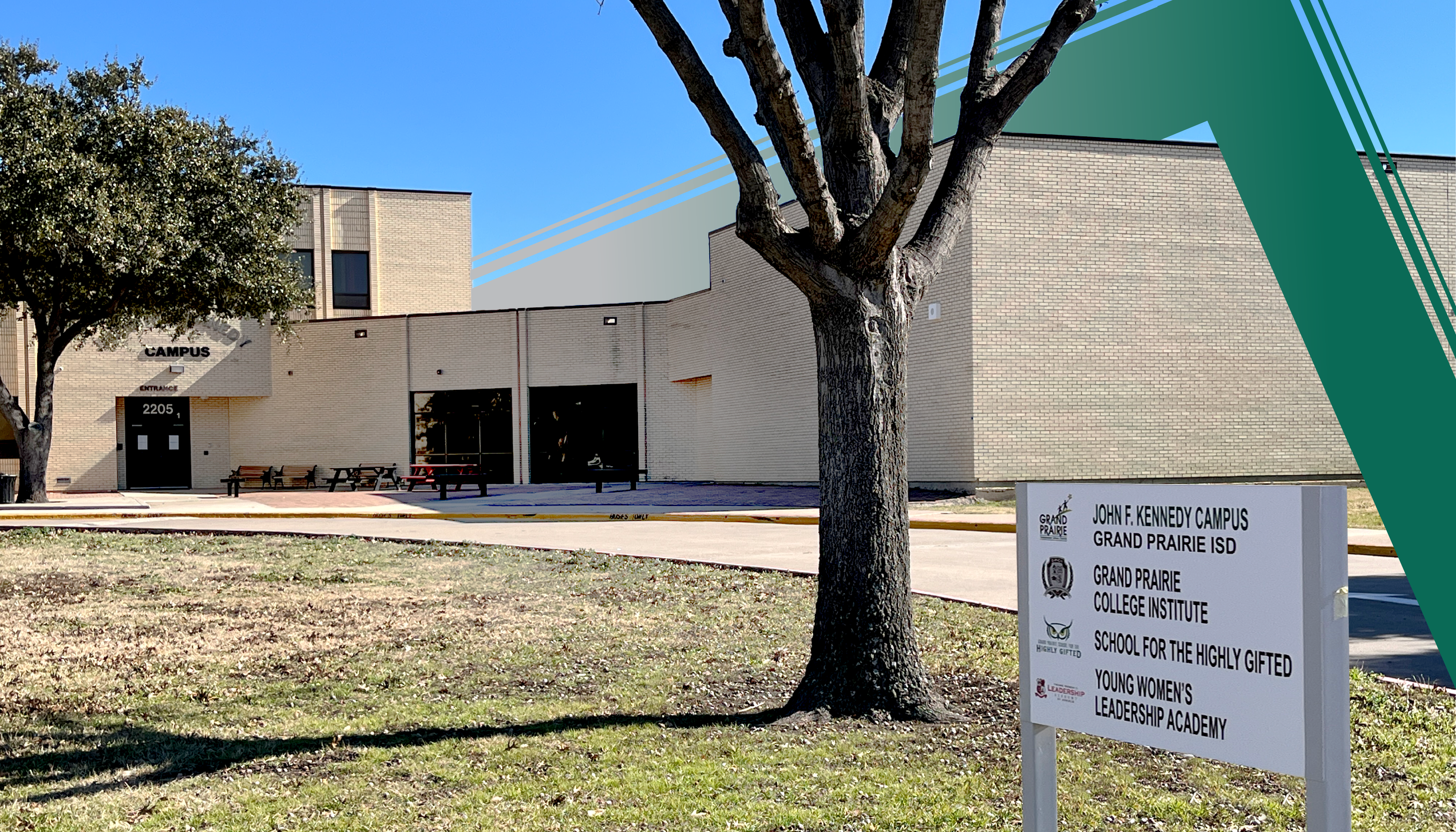 A modern brick building with a green roof stands in the foreground, surrounded by a grassy area and a tree in the foreground.
