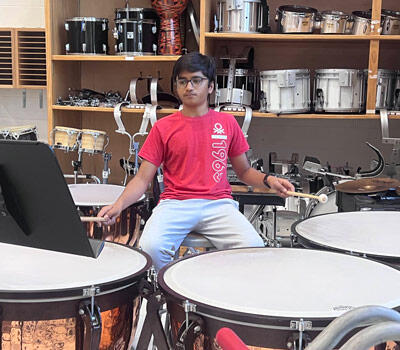 Student playing drums in a music class