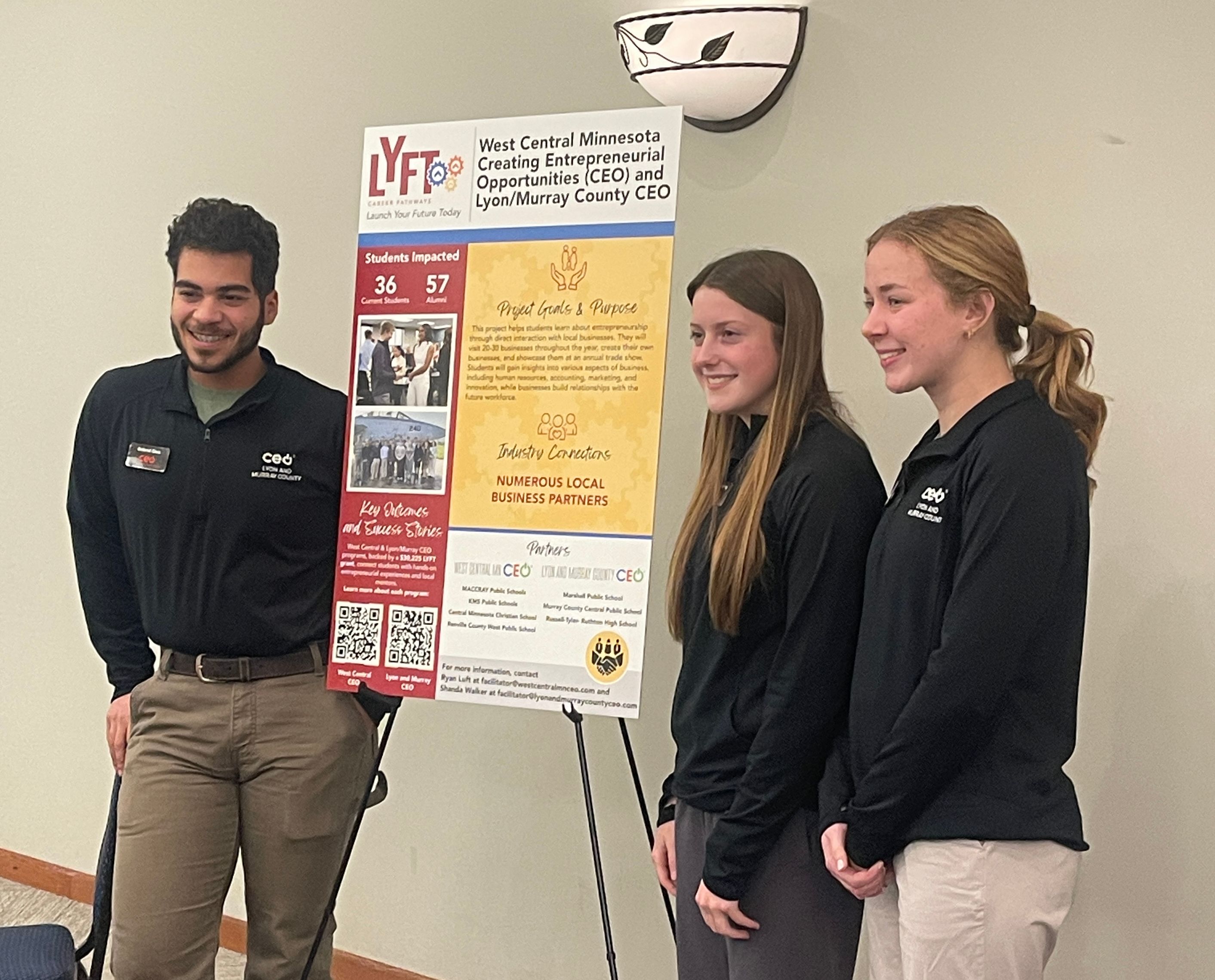 Students standing by their project board