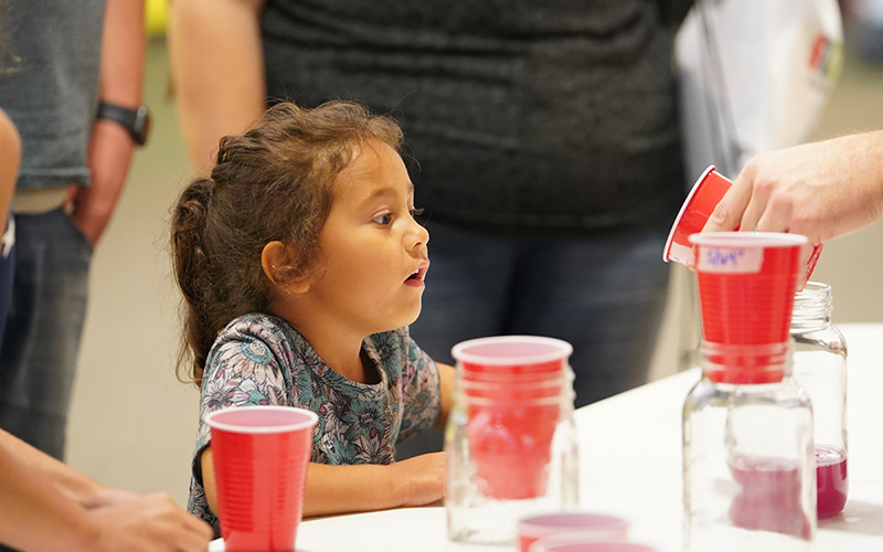 Young girl watches an experiment during STEMfest 2024