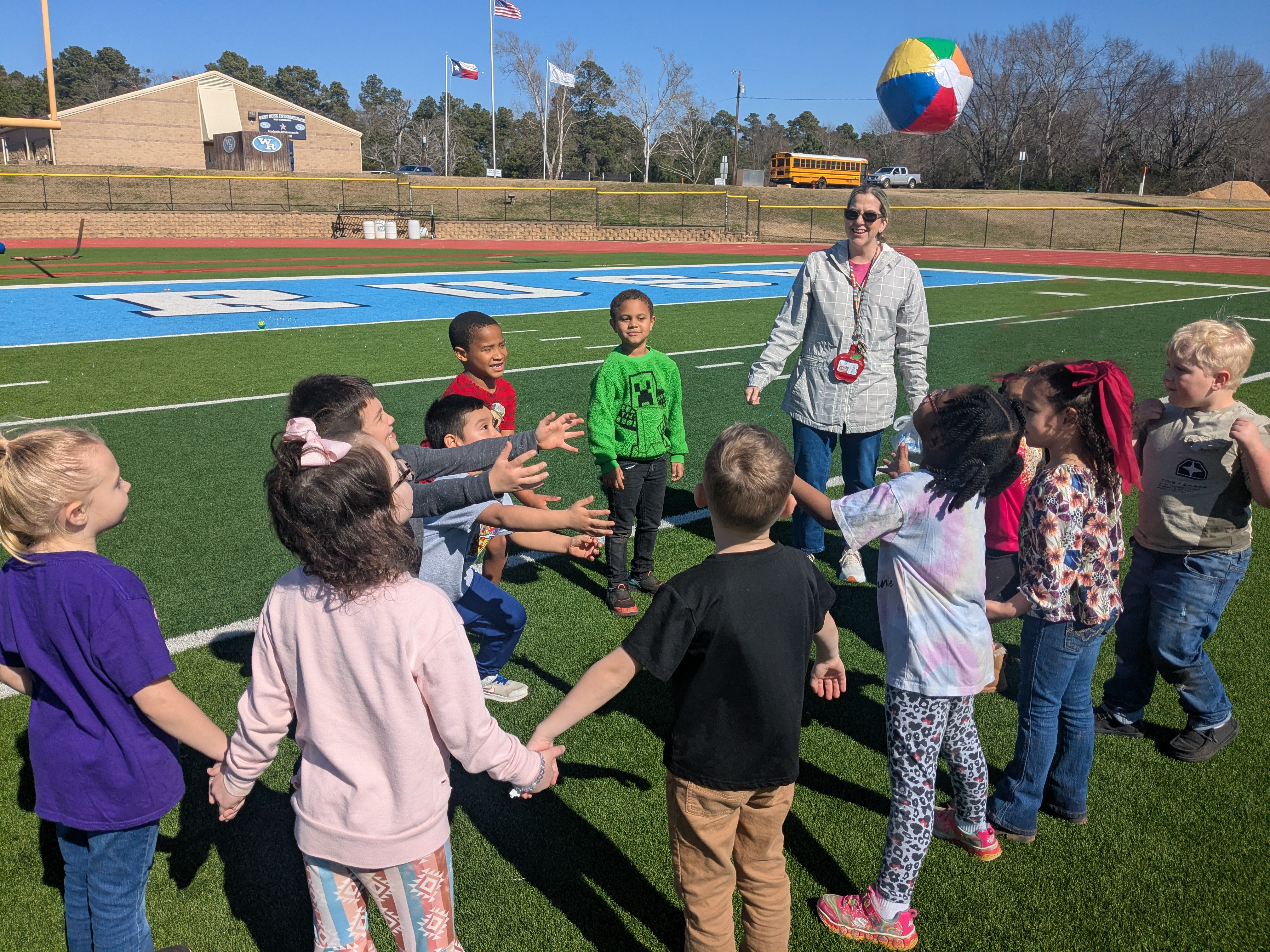 Kids in a circle playing with a beach ball