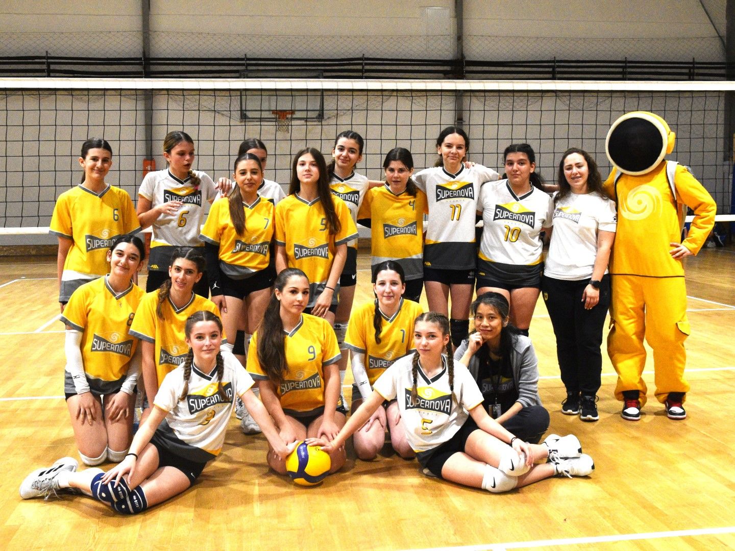 SuperNOVA girls volleyball team posing together in the gym