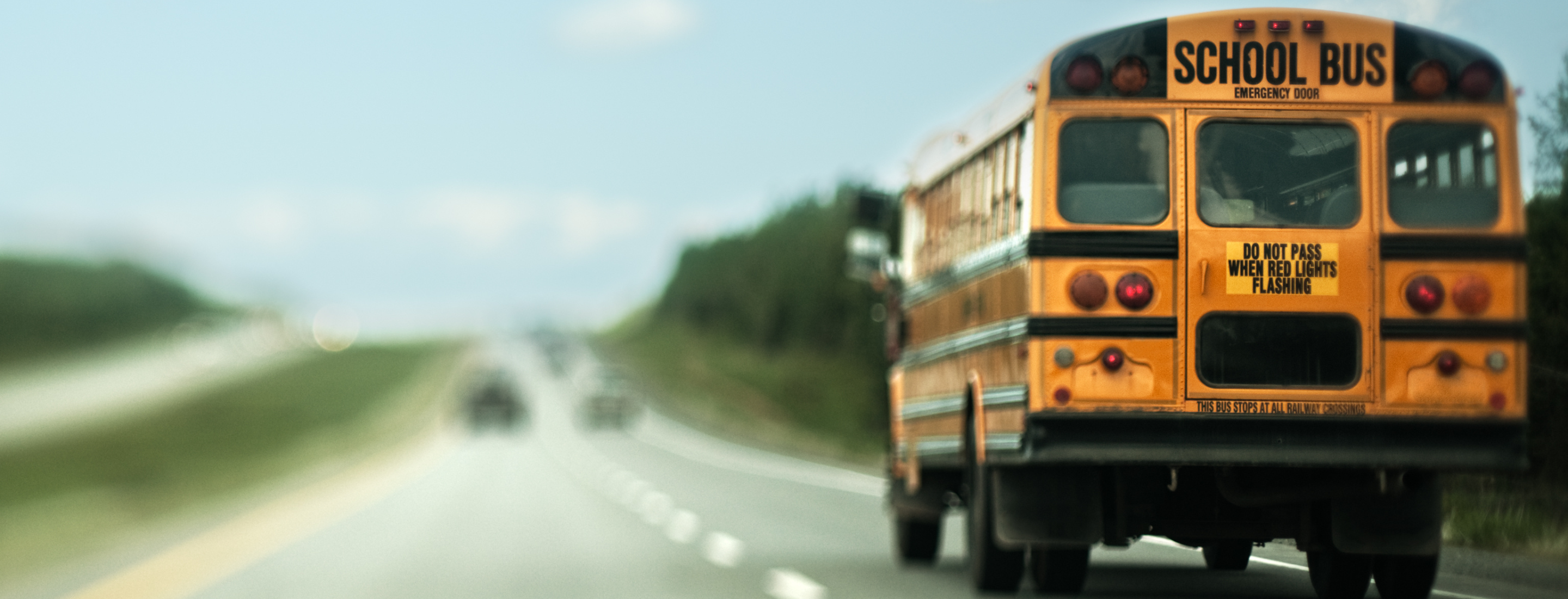 yellow bus on road. Blue sky.