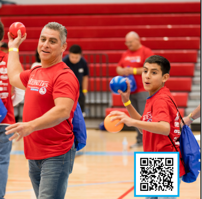 A man and a boy in red shirts are playing with balls in the foreground, while blurred figures and red bleachers fill the background.