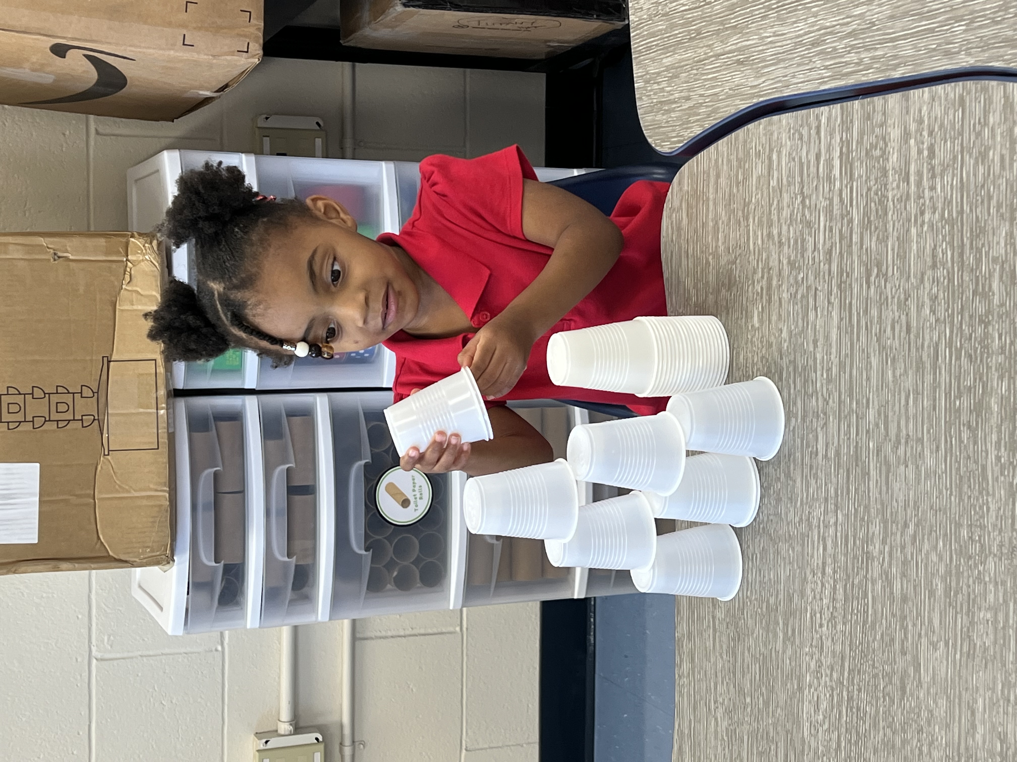 girl engineering a wall of cups
