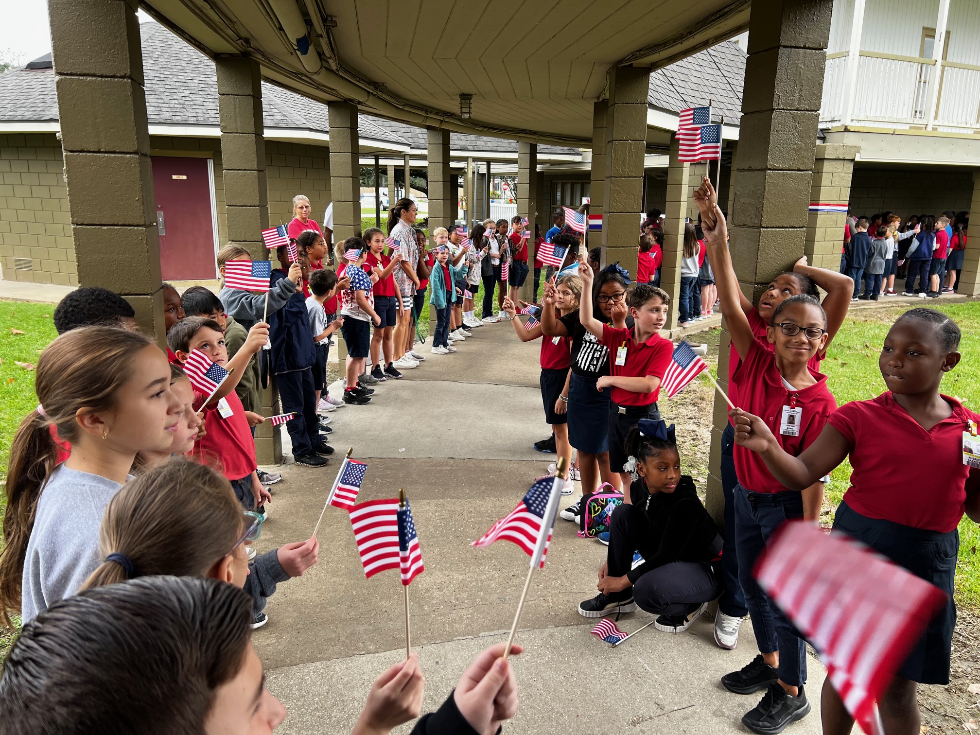 Students wave flags during the annual veterans walk at Teche's annual Veterans day Celebration. 