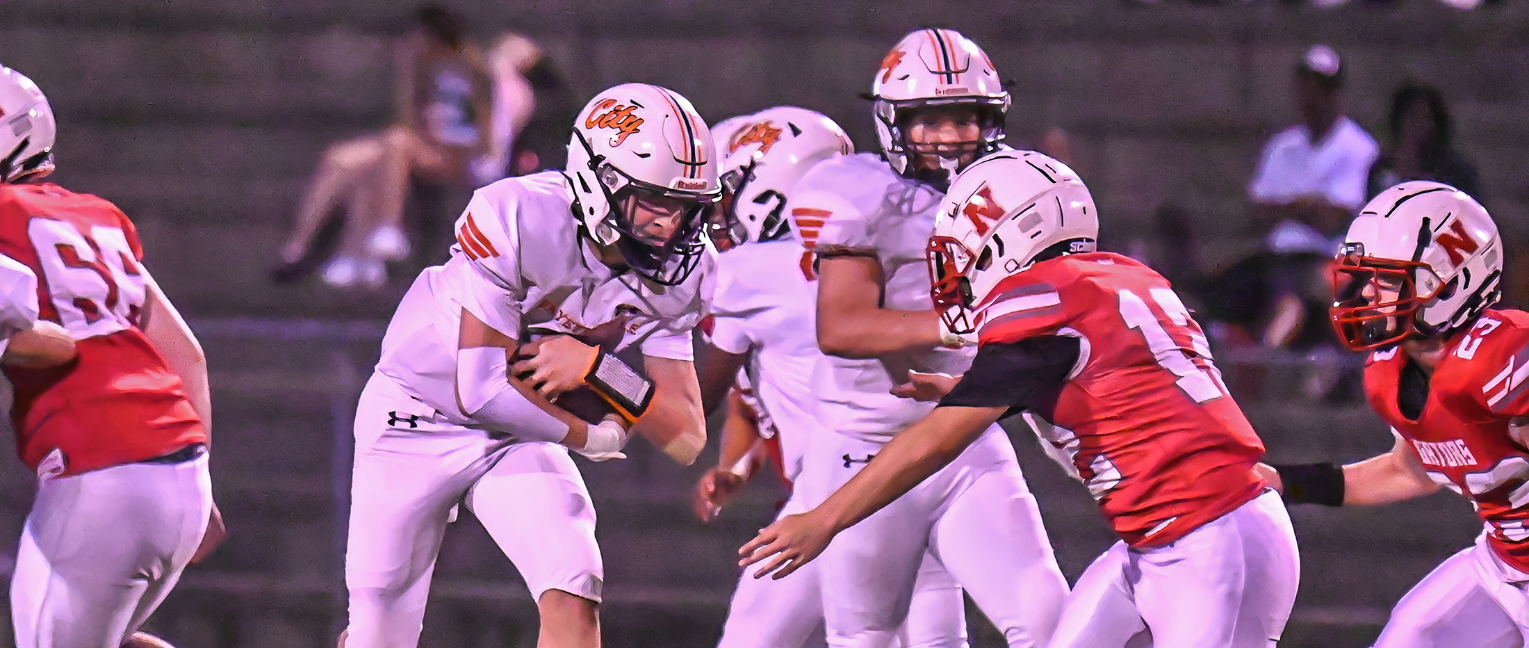 running back in white jersey runs behind his blockers 