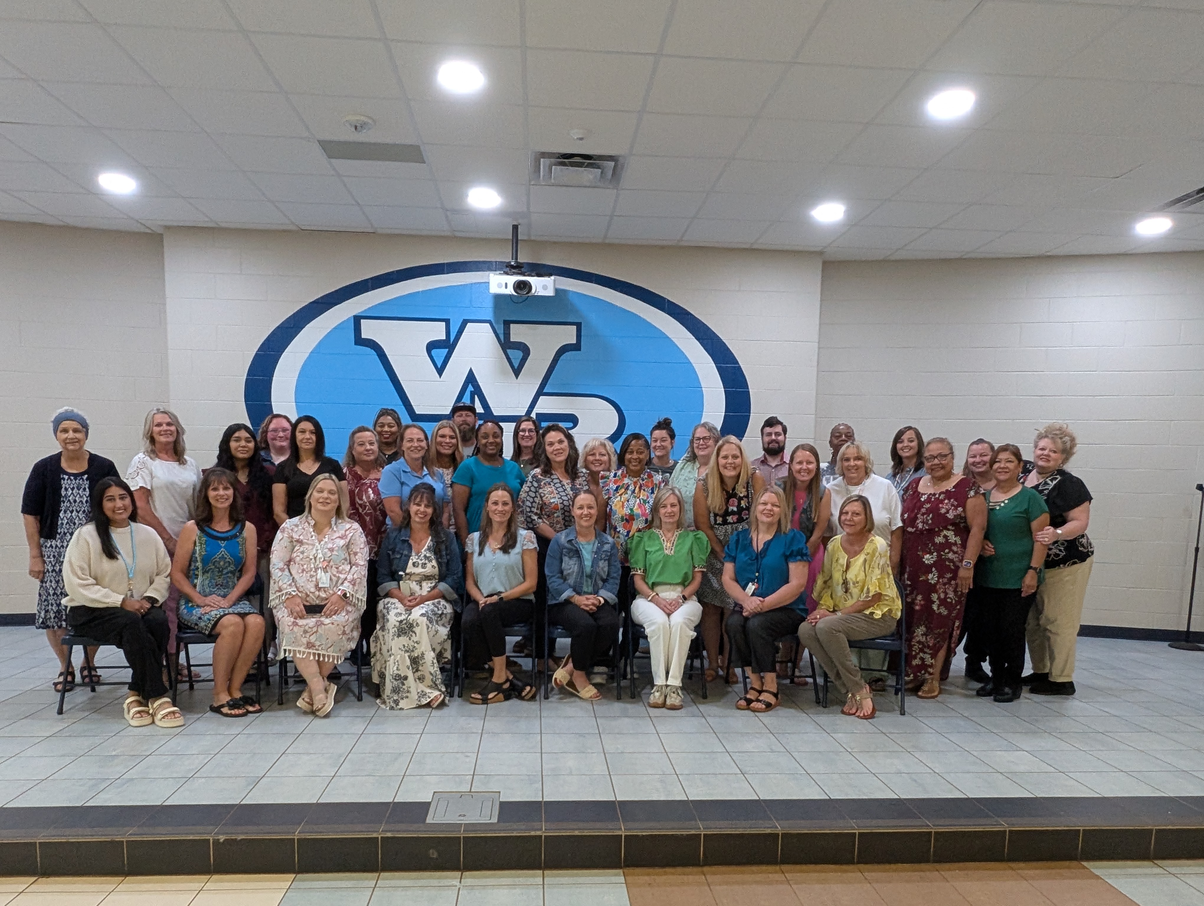 West Rusk Elementary teachers in front of the West Rusk logo.