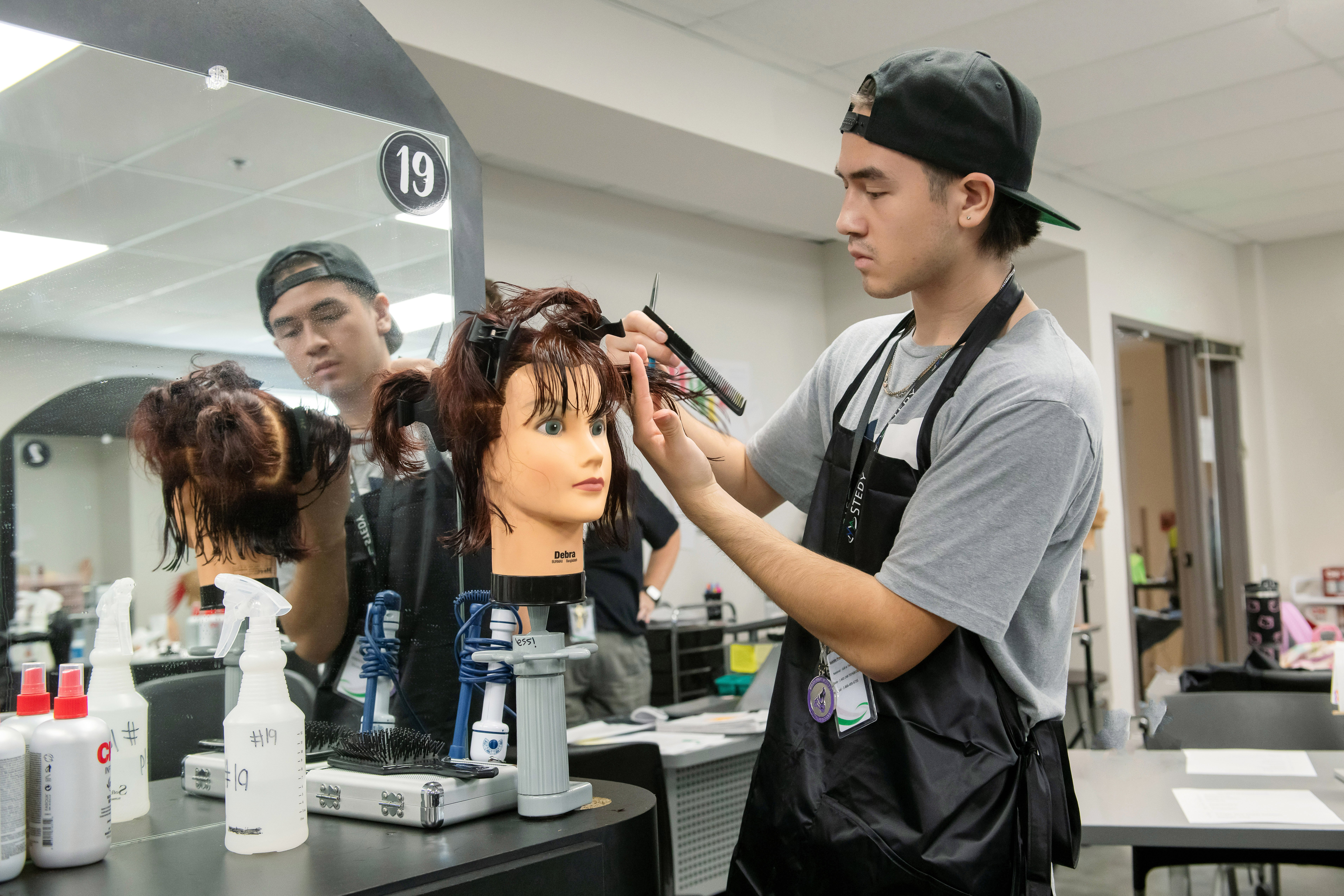 Cosmetology Student practicing haircutting