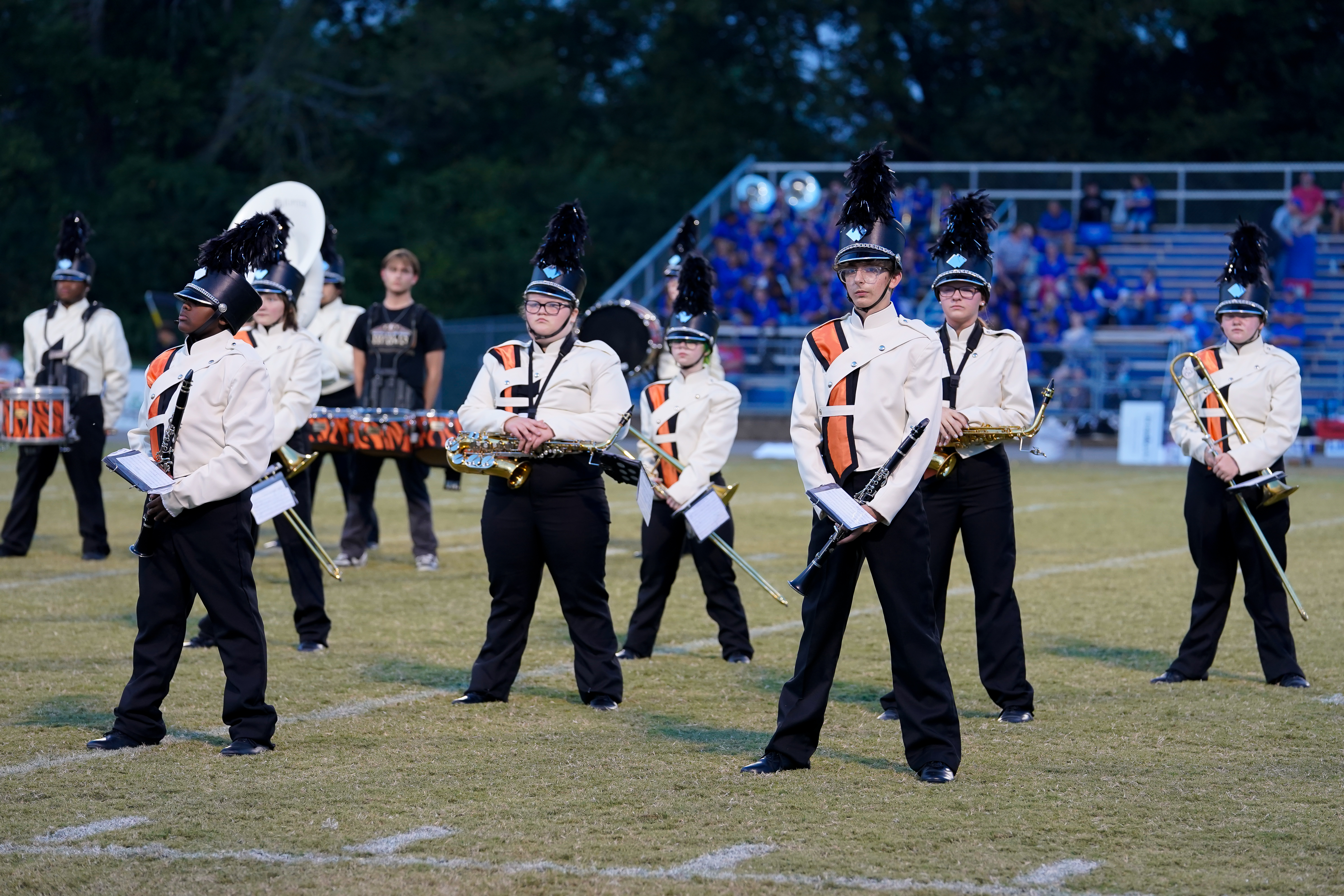 Tiger marching band performs on the field in full uniform, standing ready with instruments.