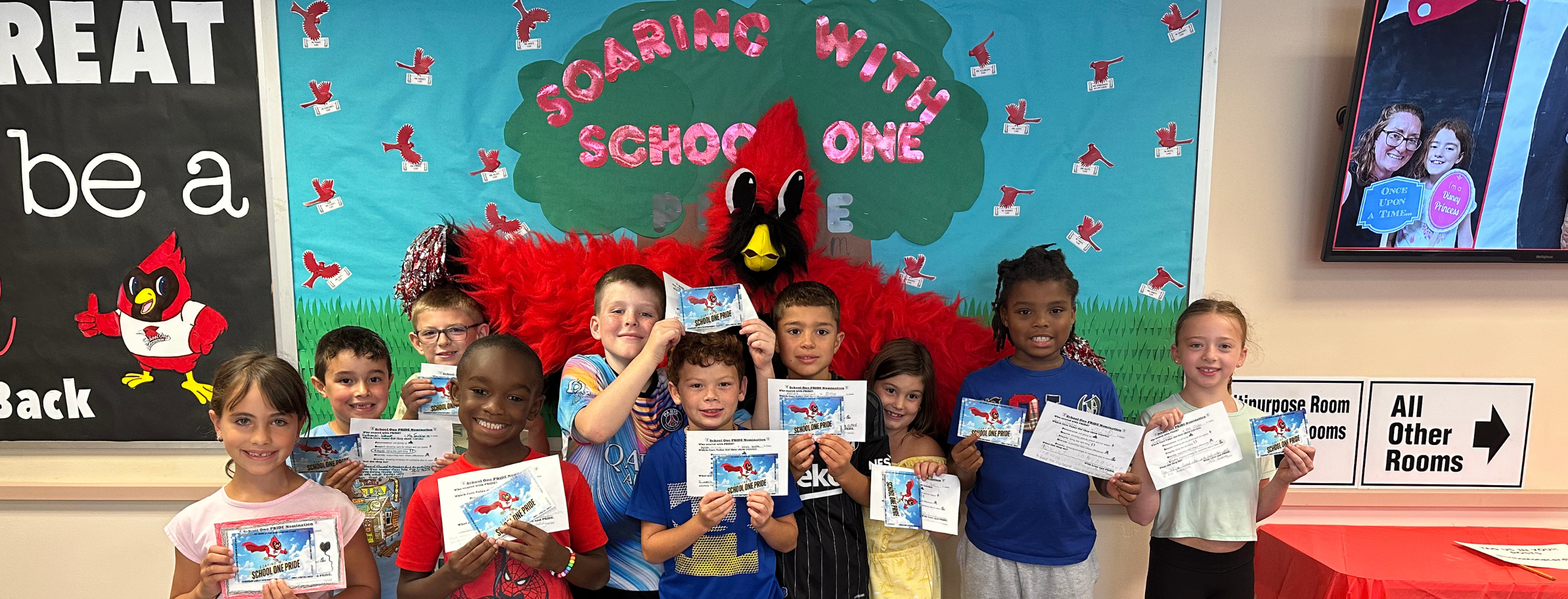 Students standing in front of school one bulletin board