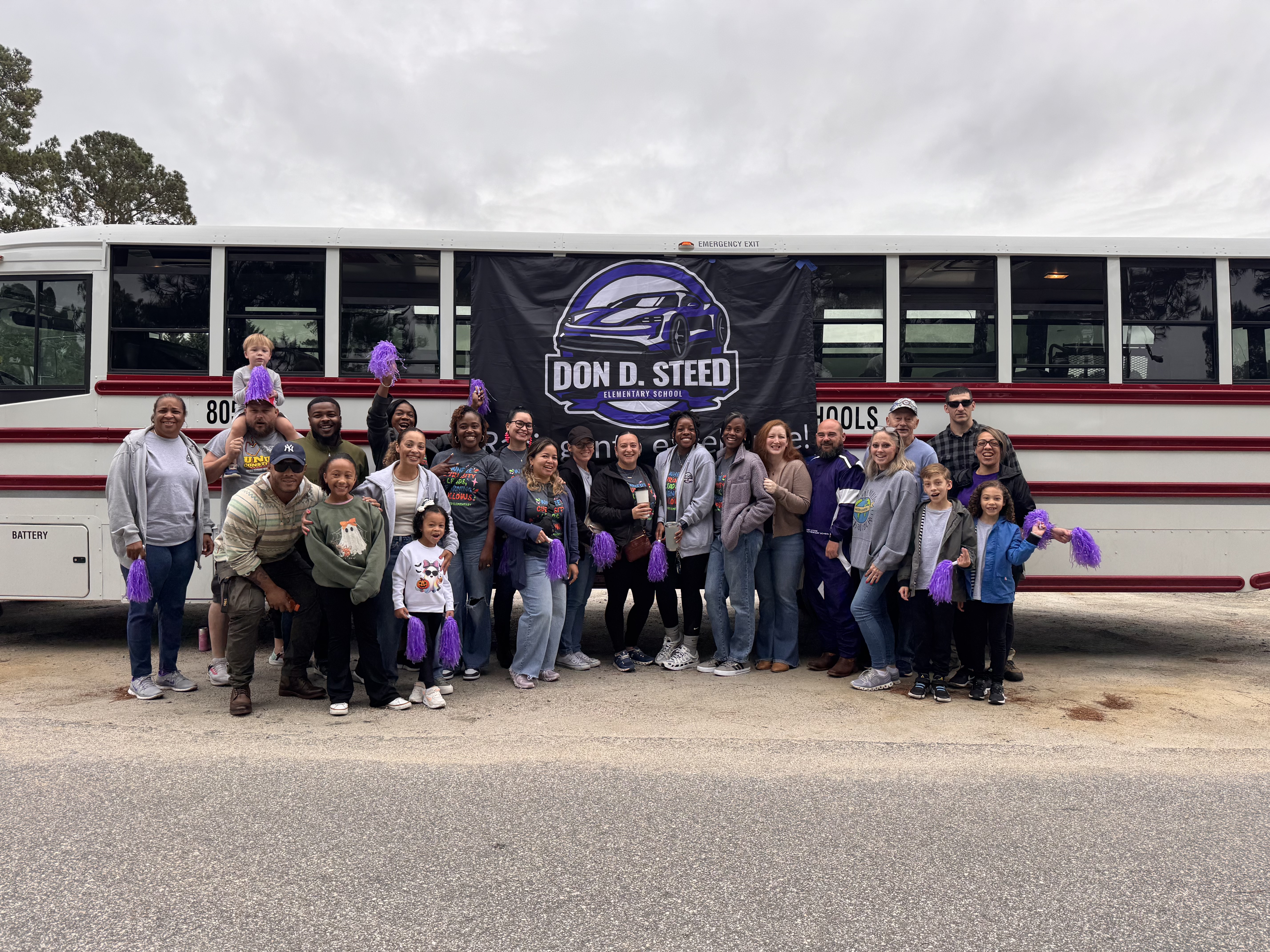 Group of teachers at the Fall Festival Parade in front of the bus