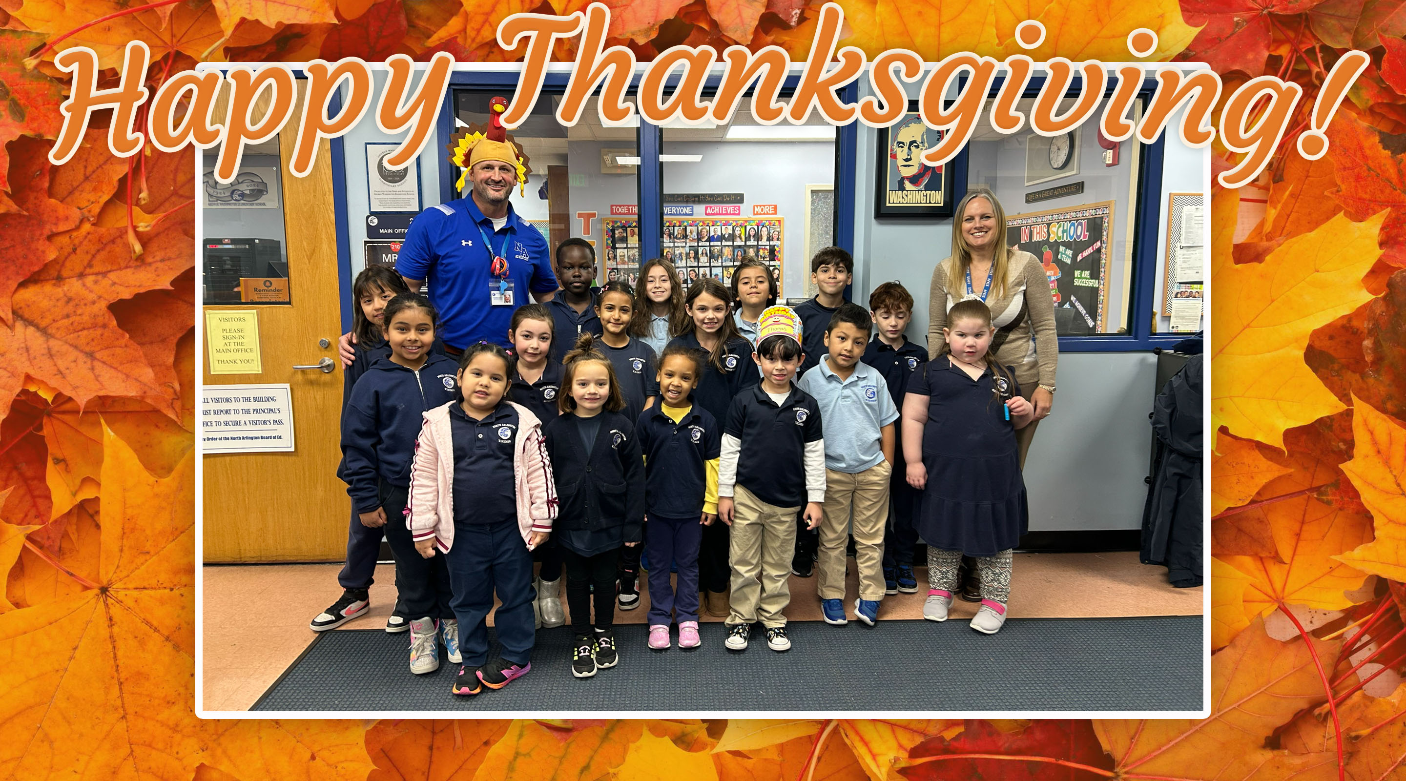 A group of children and two adults pose for a photo in front of a school hallway, framed by colorful autumn leaves and a "Happy Thanksgiving!" message.