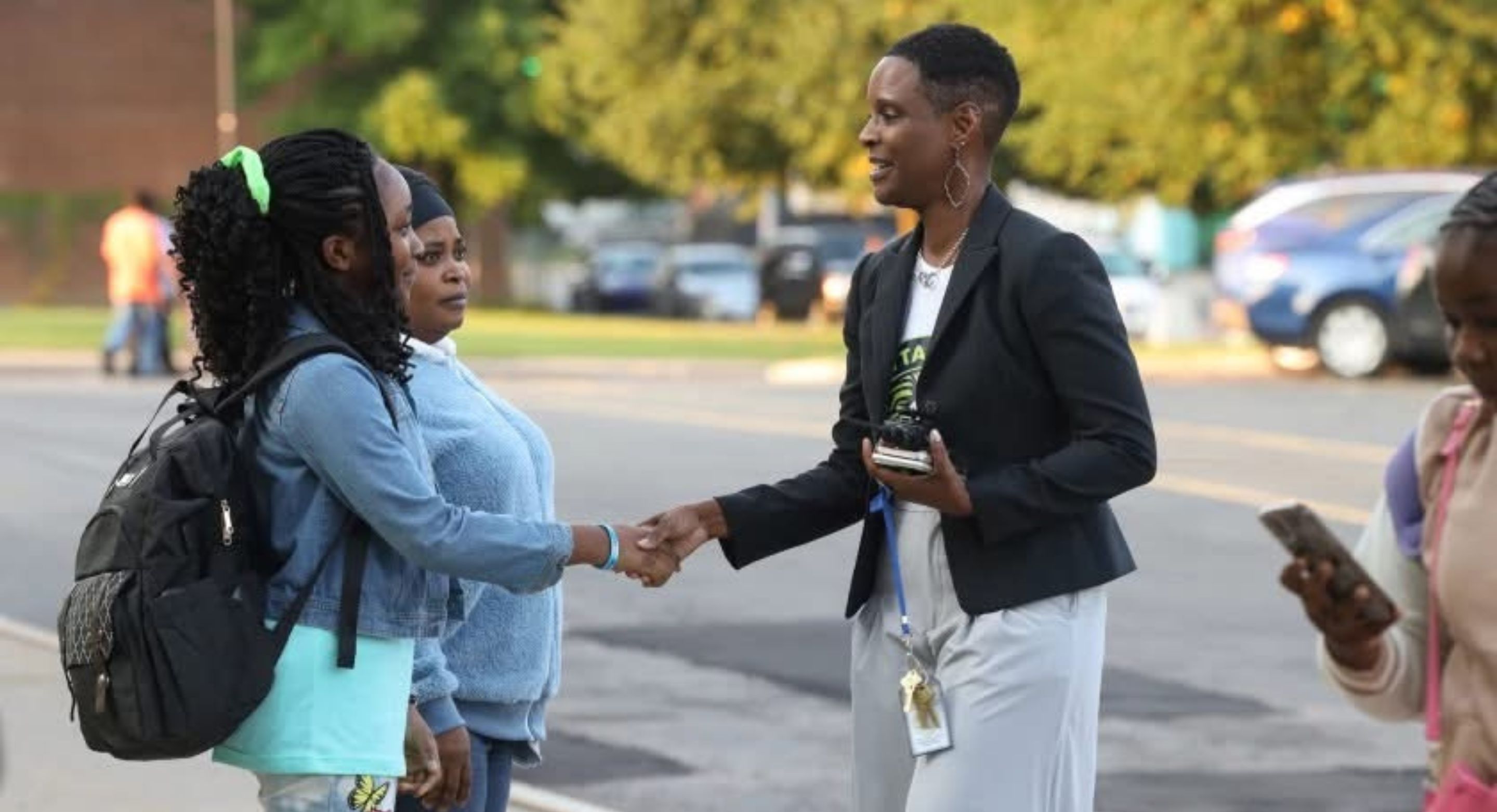 Founding Principal Moniek Silas-Lee on the first day of school, greeting students and families at the bus loop.