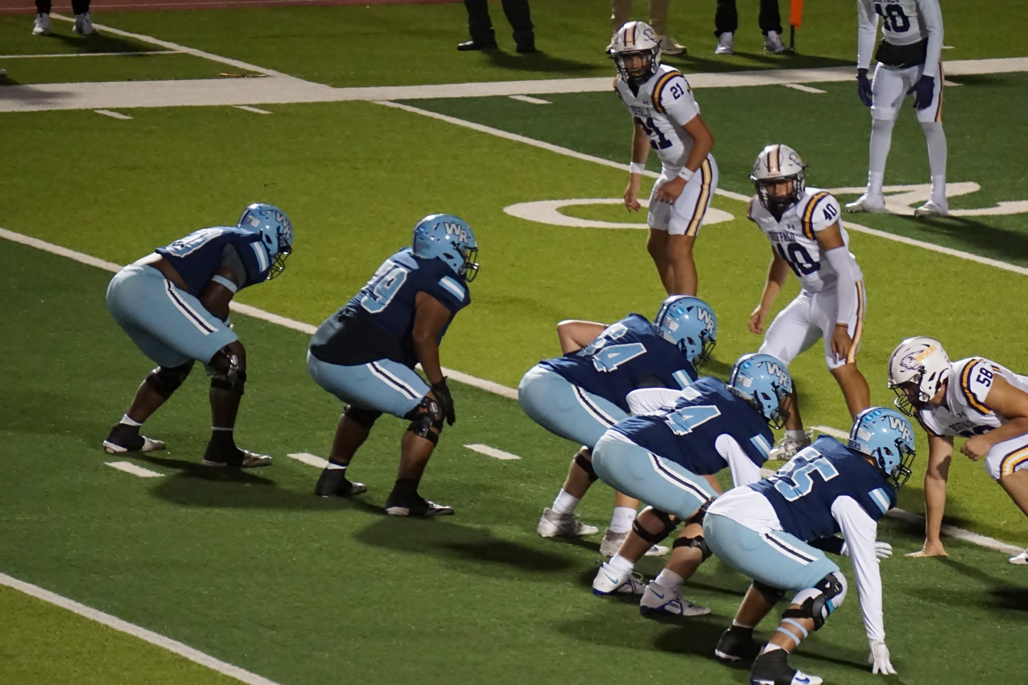 The image shows a football game in progress, with players from both teams lined up on the field, ready to engage in the next play.
