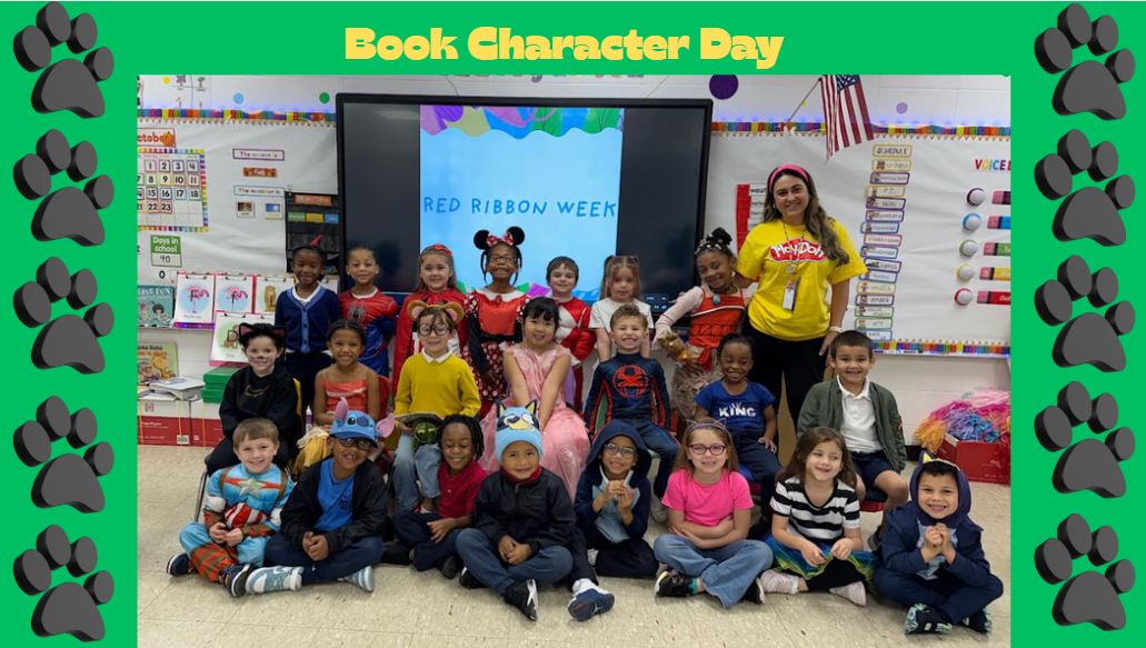 A group of children dressed as book characters pose for a photo in a classroom with a teacher, while paw prints frame the image.