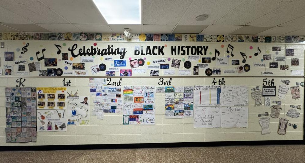 A large bulletin board displaying various items celebrating Black history, including photographs, posters, and other memorabilia, arranged in a collage-like manner.