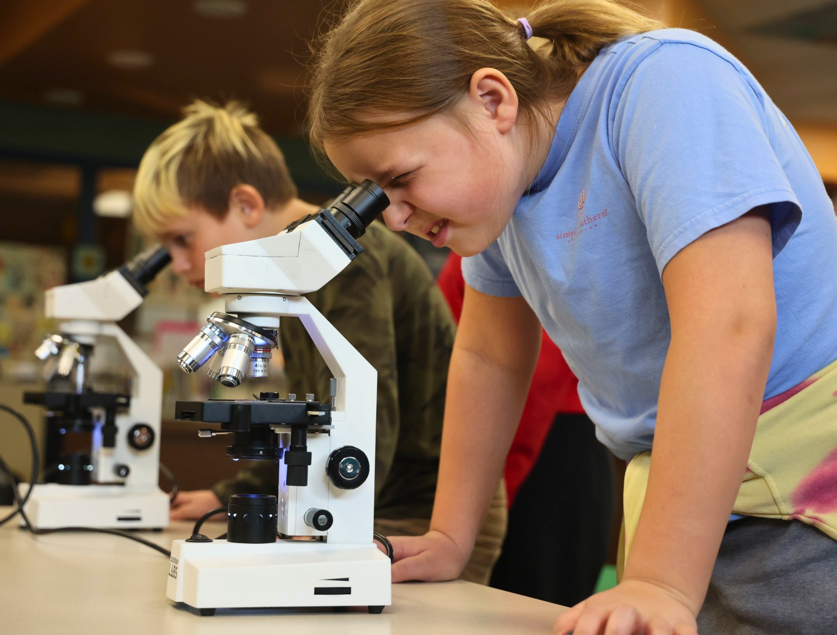 photo of child looking at mircrscope