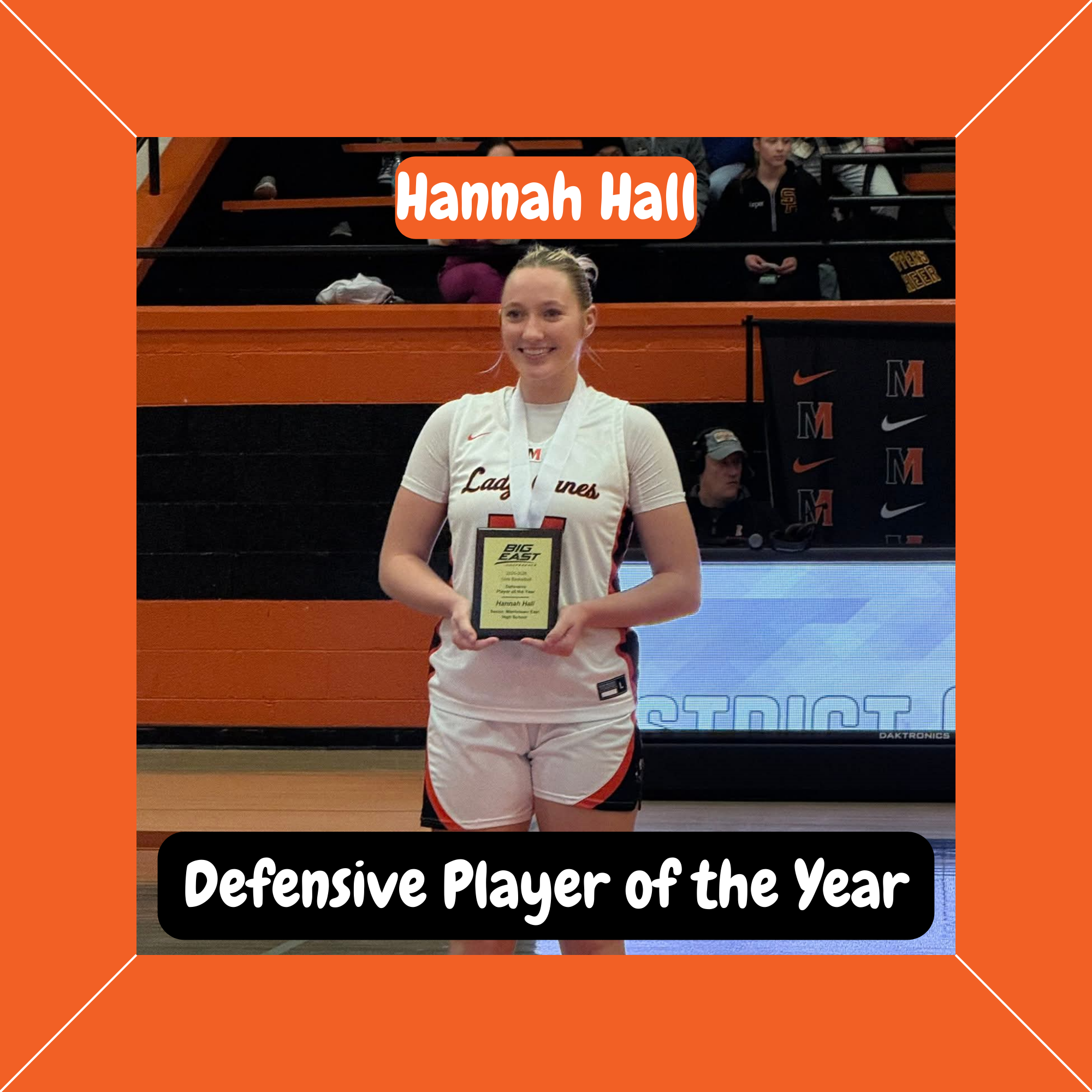 Lady Canes basketball player Hannah Hall stands on the court holding her Defensive Player of the Year award.