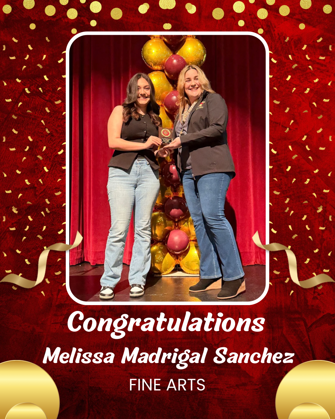The image shows two women standing in front of a red backdrop adorned with yellow polka dots and confetti, holding a certificate and surrounded by various fruits.
