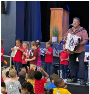 man playing accordion and children playing other instruments